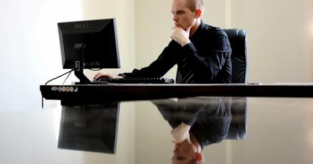 A perosn working on their desktop computer in an office.