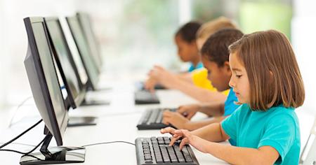 A group of students in a computer lab at school on their computers.