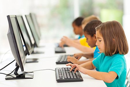 A group of students in a computer lab at school on their computers.