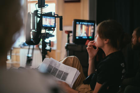 Film director reviewing footage on set with camera and monitors in foreground