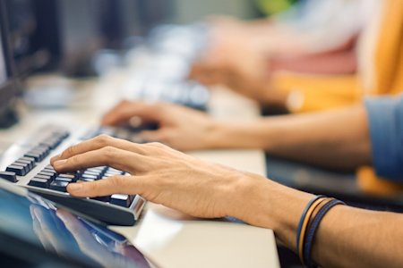 Hands typing on a computer