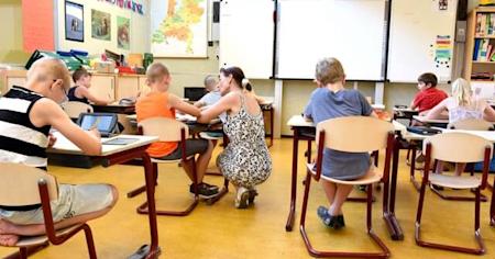 Classroom with students using tablets and a teacher assisting