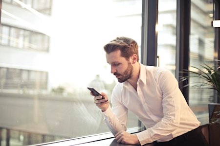 A business man using a smartphone while working.