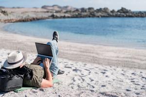 Man working on a laptop at the beach, embodying remote work with Splashtop's flexible access