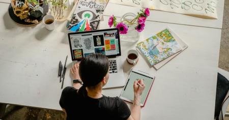 A graphic designer works on a stylus tablet while accessing a workstation remotely using Splashtop.