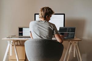 A remote worker at his home computer working digitally.