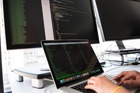 Multiple screens displaying code snippets and programming tools