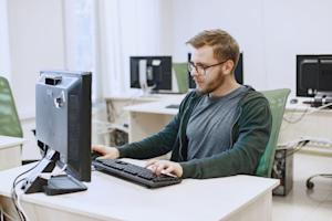 A man working on his computer in an office.