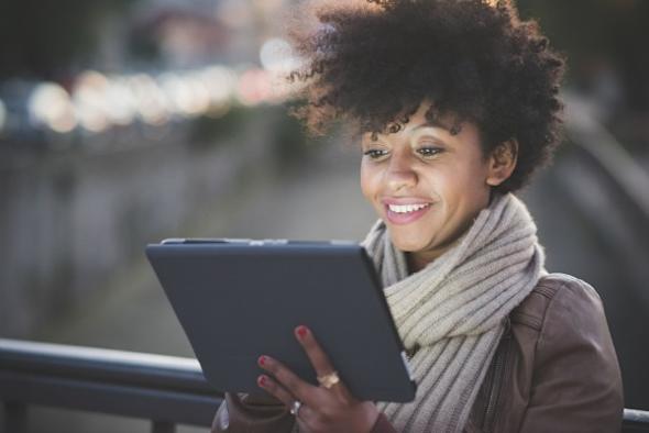 IT technician outdoors looking at a tablet and reading an informative case study by Splashtop