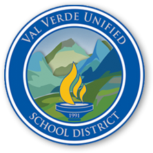 Circular logo for Val Verde Unified School District with blue border, yellow flames in the center, green hills and mountains in the background, and 1991 beneath the flames.