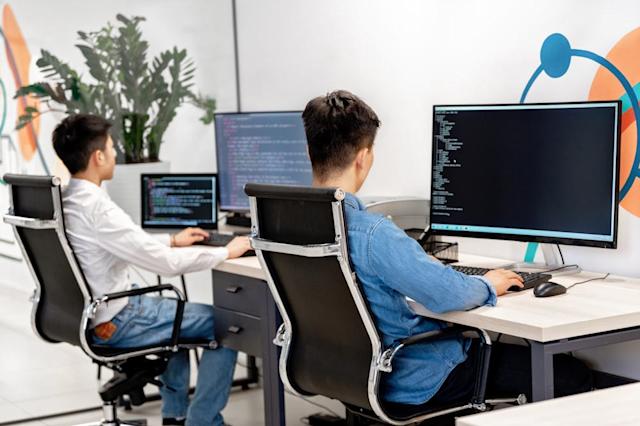 IT workers on their computers at their desks.