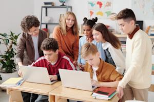 A group of students in a classroom using laptop computers.