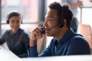 IT pro providing remote support while co-worker looks on