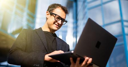 Male businessman reading Splashtop Enterprise capabilities on laptop screen