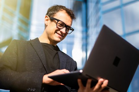 Male businessman reading Splashtop Enterprise capabilities on laptop screen