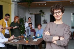 A group of happy coworkers working around a desk in an office