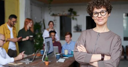 A group of happy coworkers working around a desk in an office