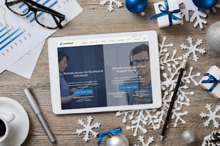 Tablet displaying Splashtop website for remote access trials on a festive desk setup