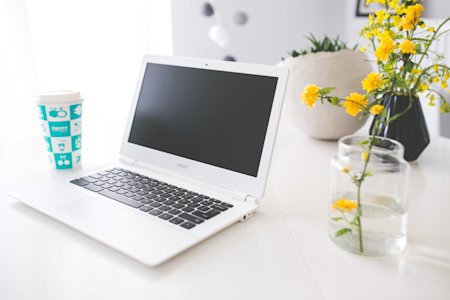 A Chromebook sitting on a desk in a home office.
