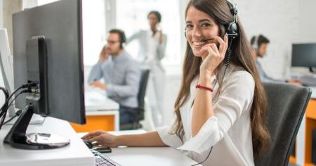 Customer service rep smiling while using a headset
