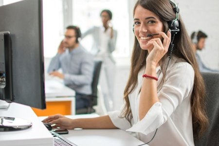 Customer service rep smiling while using a headset