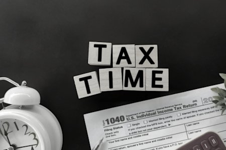 Tax time showing a clock and 1040 document in background