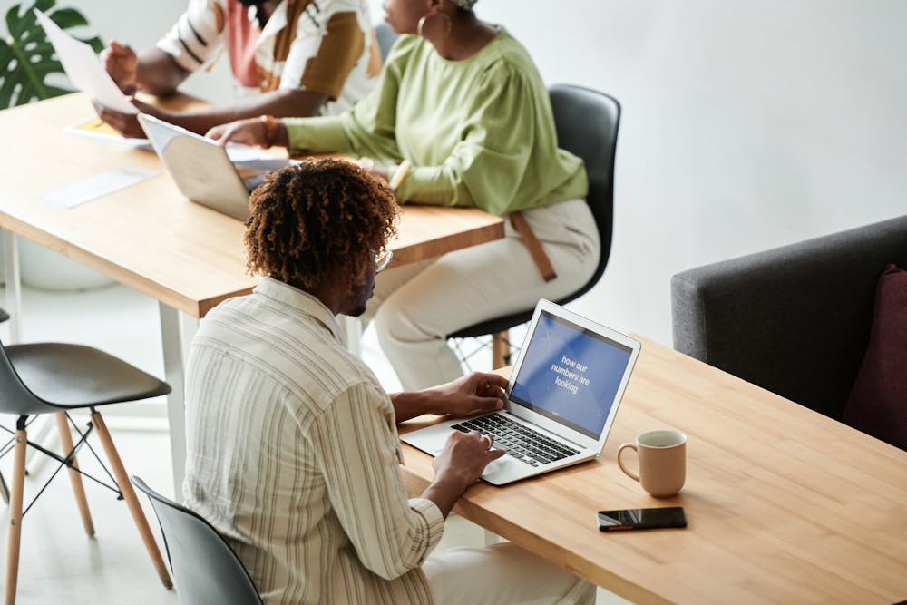 Coworkers using their laptops in an office.