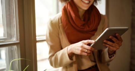 A woman using Splashtop on an iPad to remotely access a desktop computer