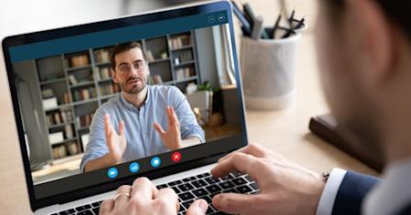 Man on a laptop with a video call on the screen