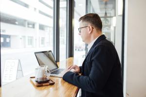 A man on a laptop in an office.