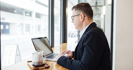 A man on a laptop in an office.