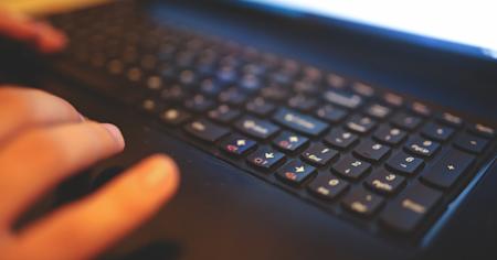 Hands typing on a keyboard.