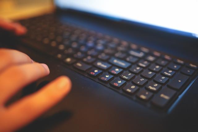 Hands typing on a keyboard.