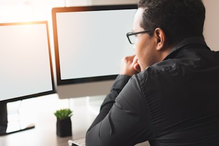 A business man using remote desktop software for dual screens.