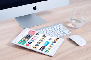 An Apple computer and a tablet on a desk.