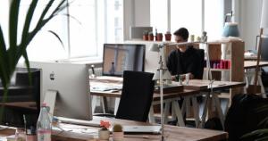 Technician in studio working at computer station reading remote work policy