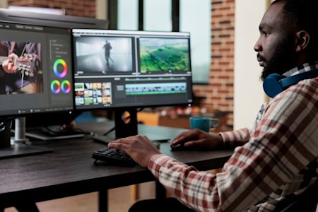 A man using Splashtop remote desktop software and viewing the multiple monitors of the remote computer on his local multi monitor display.