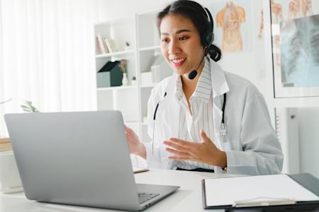 An hybrid worker in her home office, talking to a colleague on a video call.