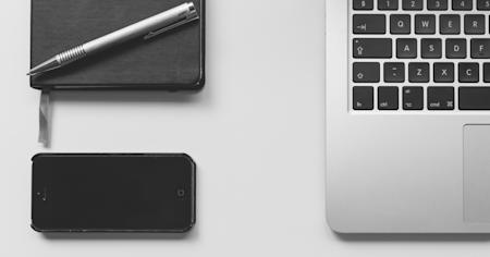 iPhone and MacBook on a desk, representing remote control and access.