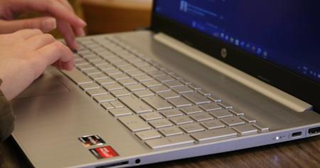 Hands typing on a laptop.