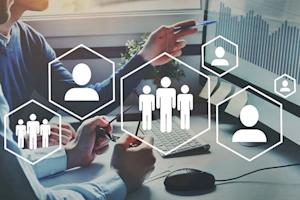 Two people point at a computer screen, superimposed by icons of generic humans