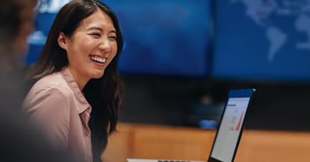 A smiling woman working with Splashtop on her laptop.