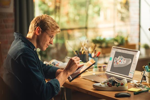 A man using a tablet and laptop with Splashtop for remote VFX editing.