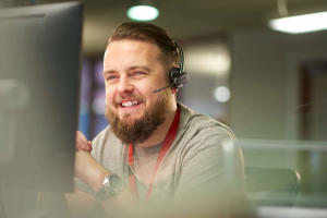 Cheerful IT technician with headset using Splashtop for remote support services