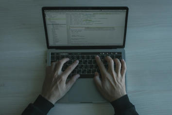 A person's hands on a laptop keyboard.