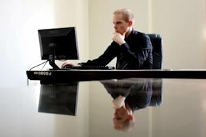 A man in an office working on a computer.
