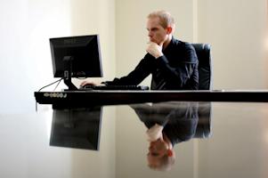 A man in an office working on a computer.
