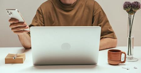 A man using his smartphone and laptop.