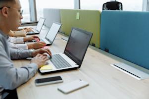 A group of employees using their computers in an office.
