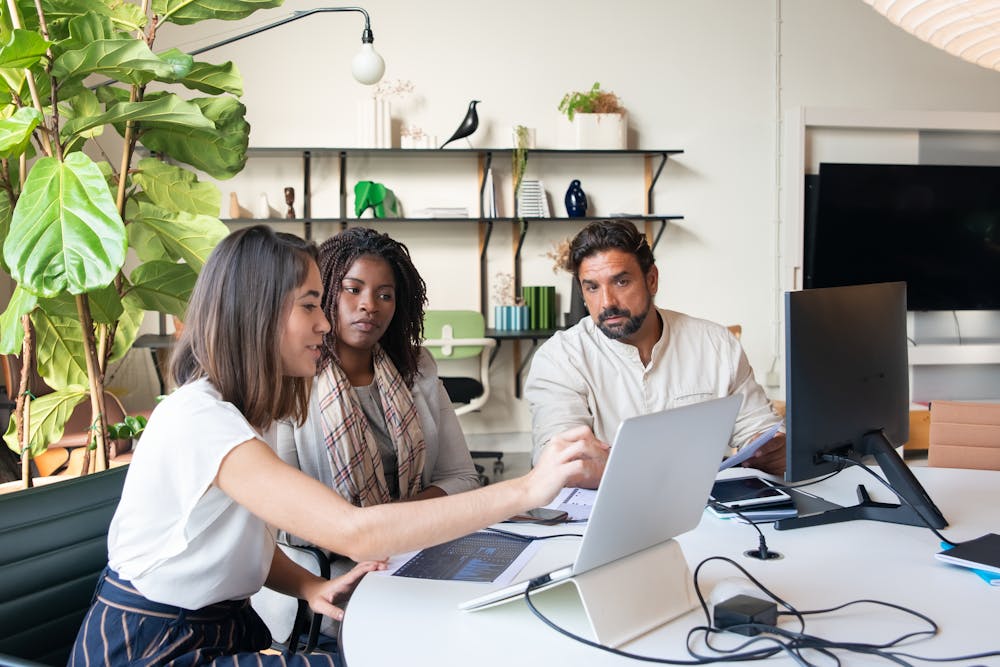 Coworkers in an office looking at a computer screen.